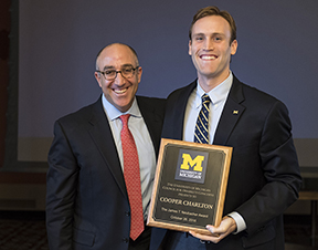 Board of Regents Chair Mark J. Bernstein (left) presents the 27th annual James T. Neubacher Award to Cooper Charlton, co-founder of the Wolverine Support Network, former Central Student Government president, and president of the Student-Athlete Advisory Committee. 